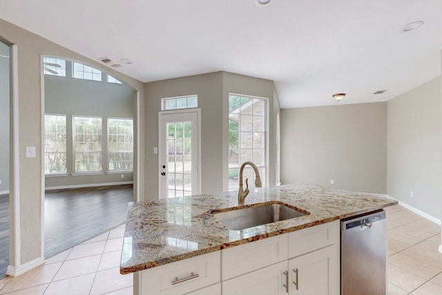 kitchen featuring dishwasher, sink, light hardwood / wood-style floors, light stone counters, and white cabinetry