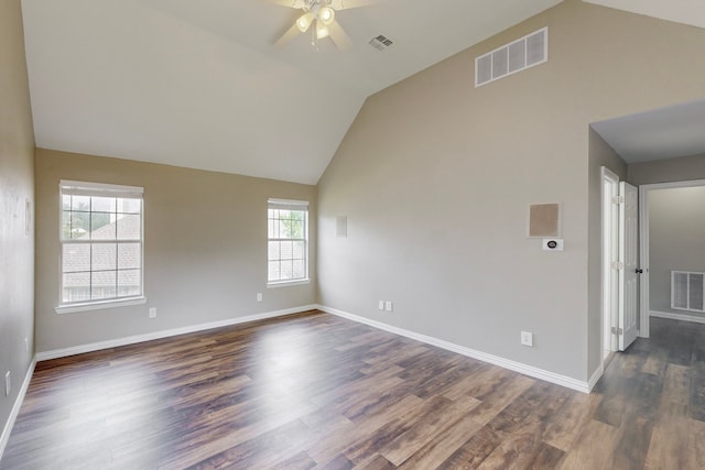 unfurnished room with a healthy amount of sunlight, dark hardwood / wood-style flooring, and lofted ceiling