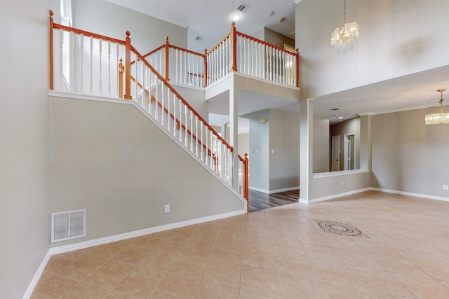 unfurnished living room with a chandelier, a high ceiling, and light tile patterned floors