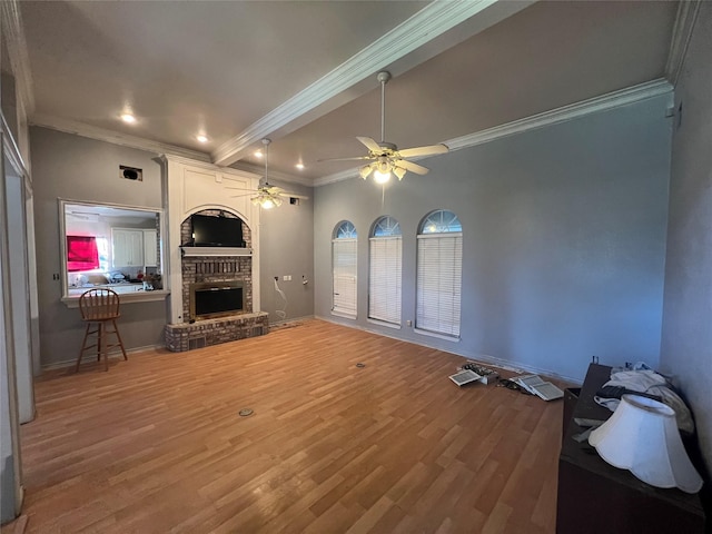 living room with crown molding, a fireplace, a ceiling fan, wood finished floors, and baseboards