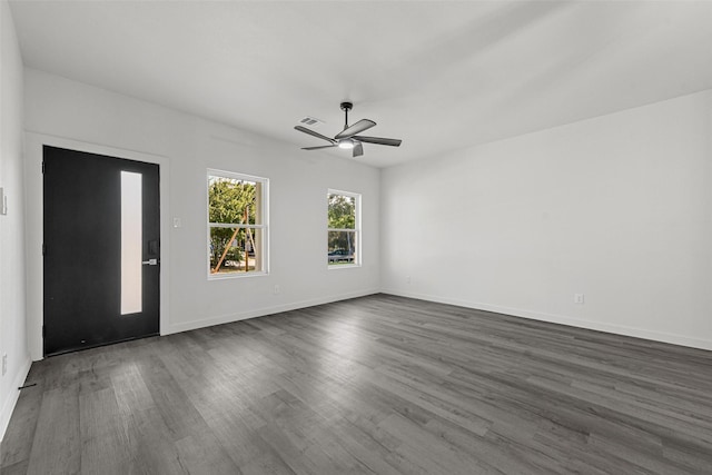 empty room with ceiling fan and dark hardwood / wood-style flooring