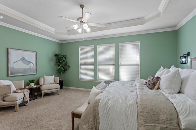 carpeted bedroom with ceiling fan, a raised ceiling, and crown molding