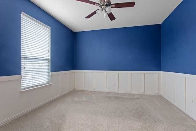 carpeted spare room featuring ceiling fan