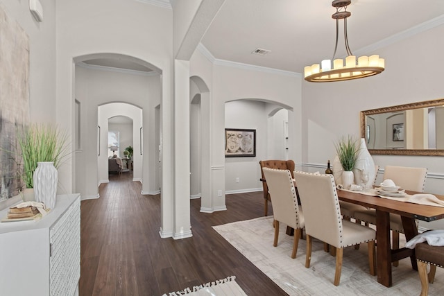 dining area featuring an inviting chandelier, dark wood-type flooring, and ornamental molding