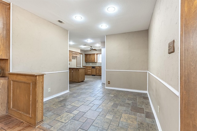 unfurnished living room with ceiling fan and a textured ceiling