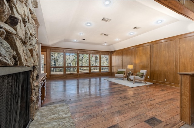 unfurnished room with lofted ceiling, a fireplace, and dark hardwood / wood-style flooring