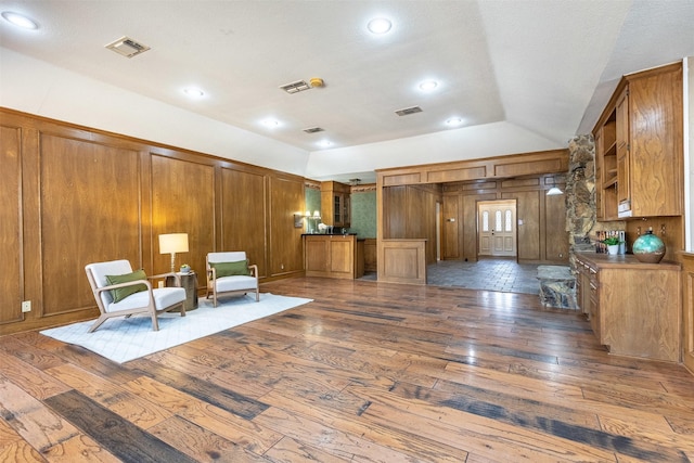 unfurnished room featuring lofted ceiling, dark hardwood / wood-style floors, and wood walls