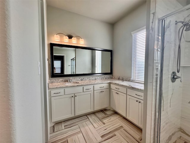 bathroom featuring vanity, a shower with door, and parquet floors