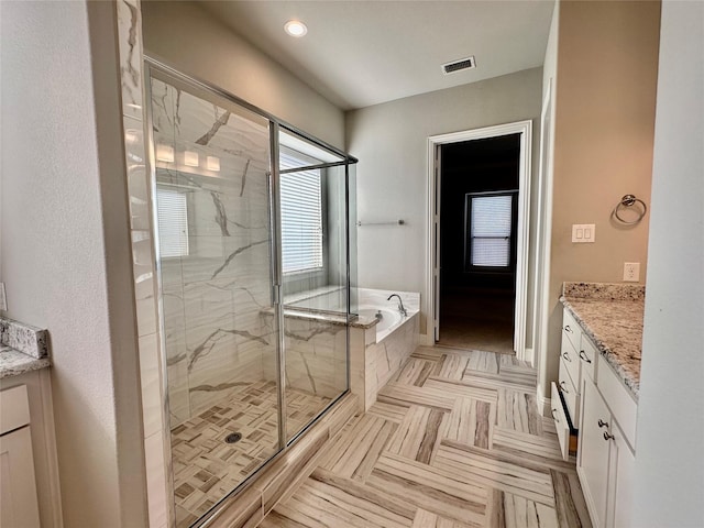 bathroom with vanity and independent shower and bath