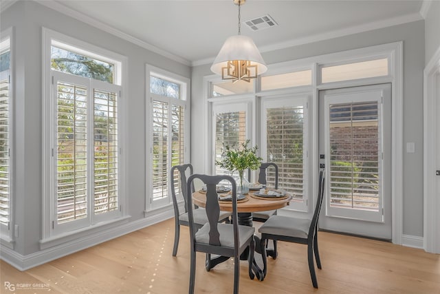 dining room with crown molding and light hardwood / wood-style floors