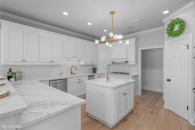 kitchen with appliances with stainless steel finishes, pendant lighting, white cabinets, a kitchen island with sink, and crown molding