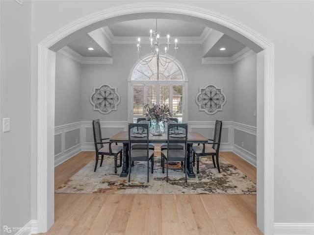 dining area with an inviting chandelier, crown molding, and wood-type flooring