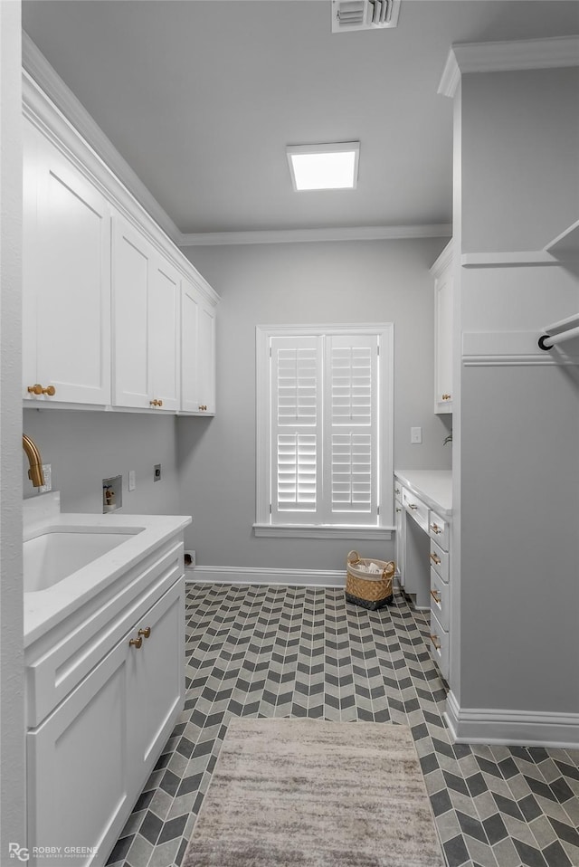 laundry area with sink, crown molding, cabinets, washer hookup, and hookup for an electric dryer