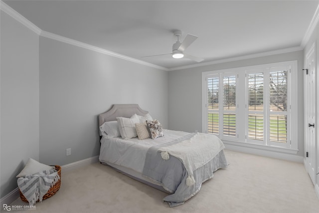 carpeted bedroom with ornamental molding and ceiling fan