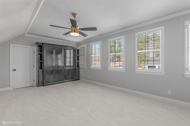 unfurnished bedroom with crown molding, vaulted ceiling, ceiling fan, and carpet