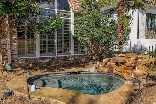 view of swimming pool featuring an in ground hot tub