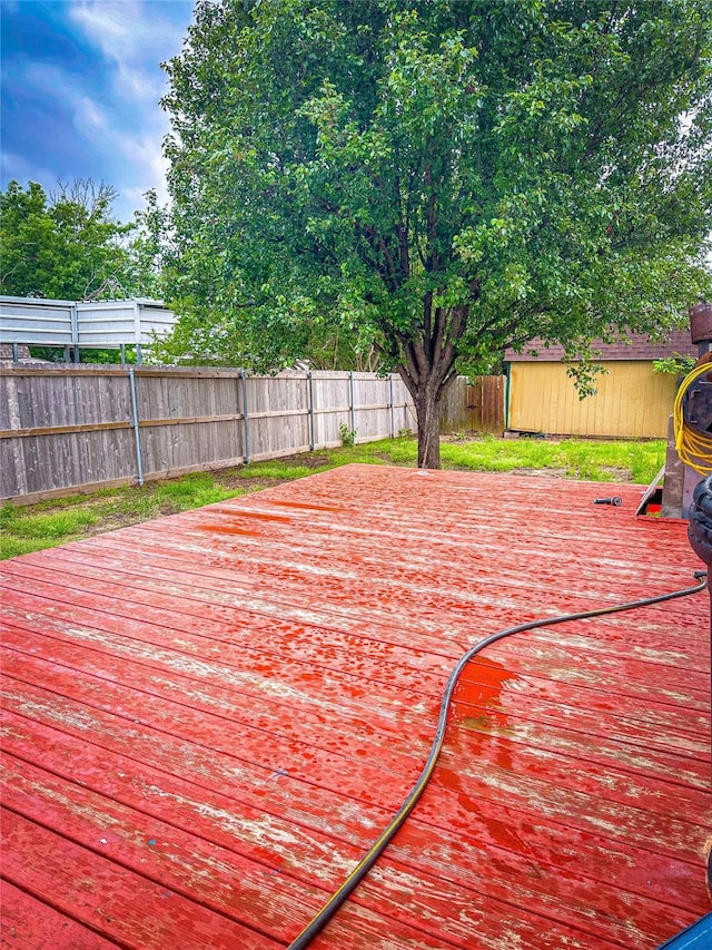 wooden deck featuring a storage unit