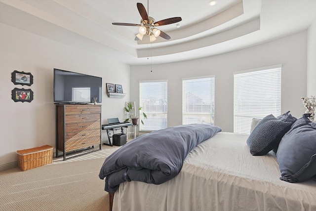 bedroom featuring carpet, ceiling fan, and a raised ceiling