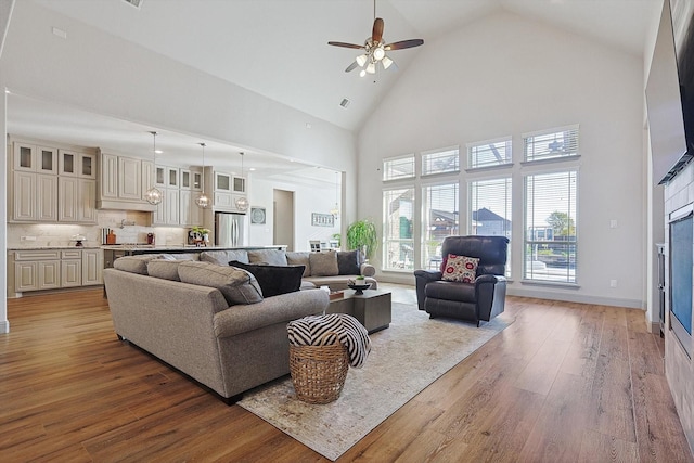 living room featuring ceiling fan, hardwood / wood-style floors, and high vaulted ceiling