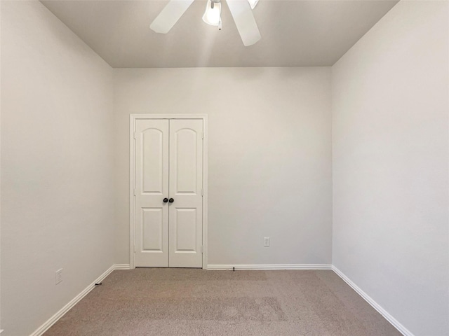 carpeted spare room featuring ceiling fan