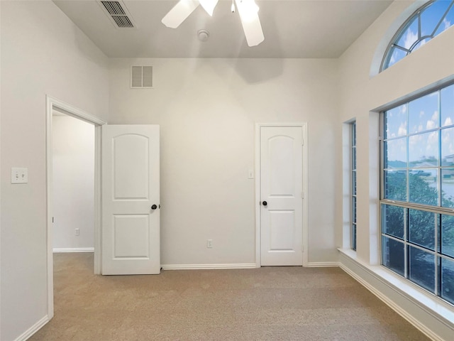 spare room featuring ceiling fan and light carpet