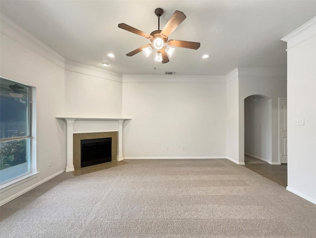 unfurnished living room with dark colored carpet, ceiling fan, and crown molding