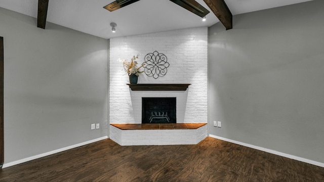 unfurnished living room featuring hardwood / wood-style flooring, lofted ceiling with beams, and a brick fireplace