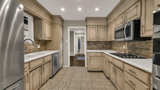 kitchen with light tile patterned floors, stainless steel appliances, light brown cabinetry, and sink