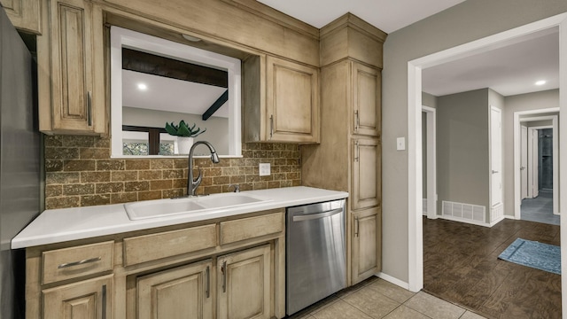 kitchen featuring tasteful backsplash, sink, light brown cabinets, light hardwood / wood-style flooring, and dishwasher