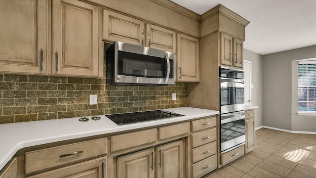 kitchen with light tile patterned floors, appliances with stainless steel finishes, and tasteful backsplash