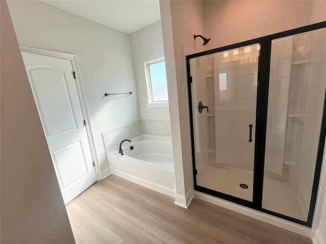 bathroom featuring shower with separate bathtub and hardwood / wood-style floors