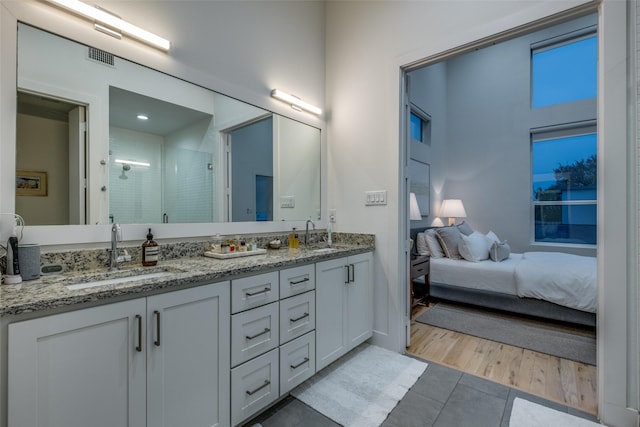 bathroom with hardwood / wood-style flooring, vanity, and an enclosed shower