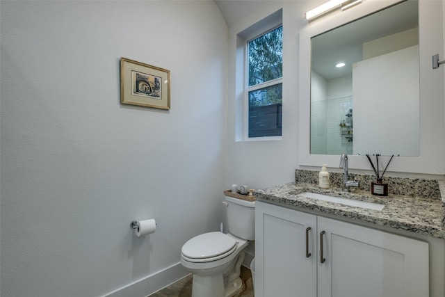 bathroom with walk in shower, vanity, and toilet