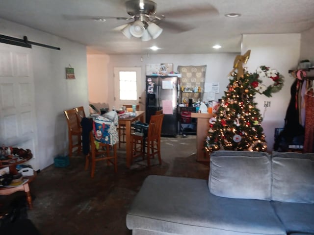 living room featuring a barn door and ceiling fan