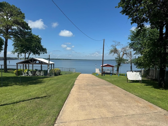 dock area featuring a gazebo, a lawn, and a water view