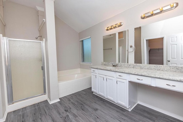 bathroom with lofted ceiling, separate shower and tub, wood-type flooring, and vanity