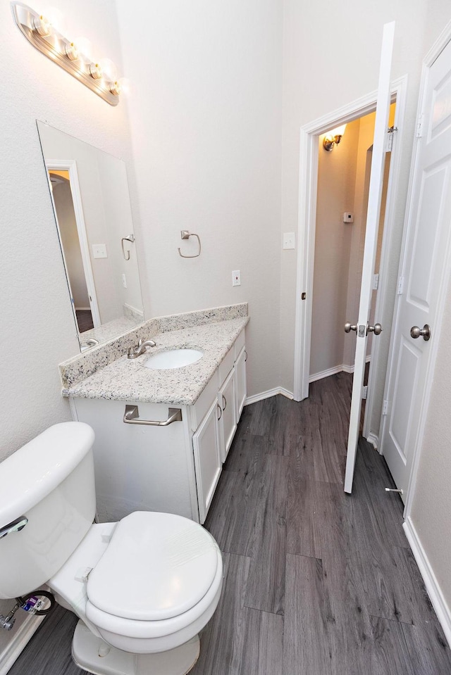 bathroom featuring vanity, wood-type flooring, and toilet