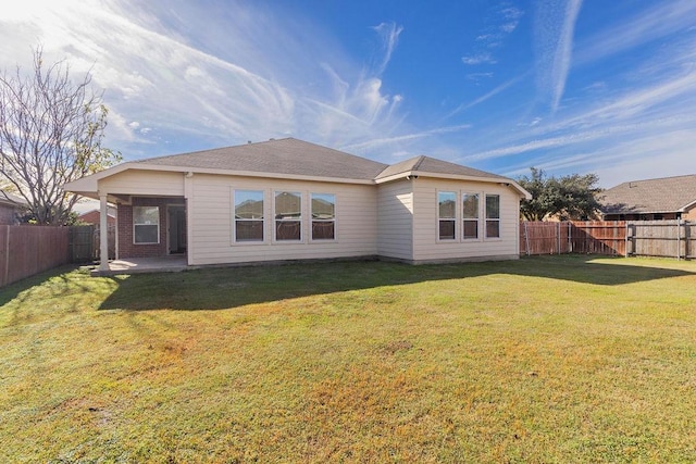 rear view of property with a lawn and a patio