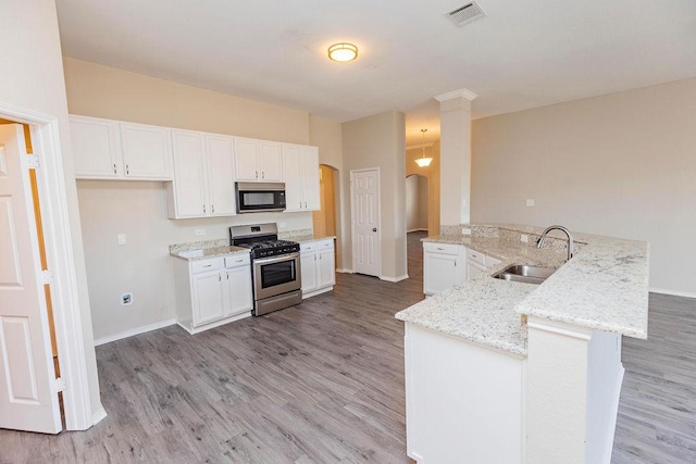 kitchen with white cabinets, kitchen peninsula, sink, and gas range