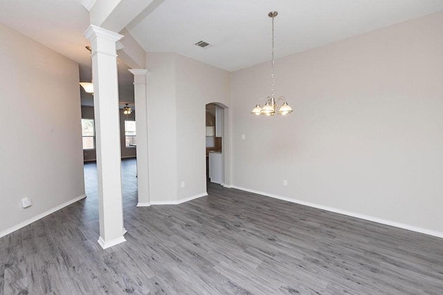 interior space with a notable chandelier, dark hardwood / wood-style floors, and ornate columns