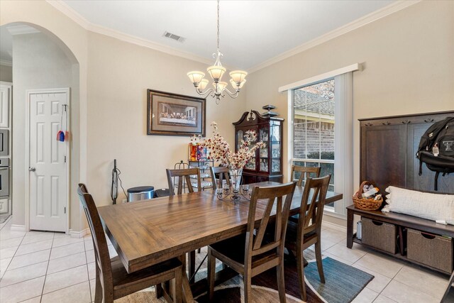 dining room with an inviting chandelier, crown molding, and light tile patterned flooring