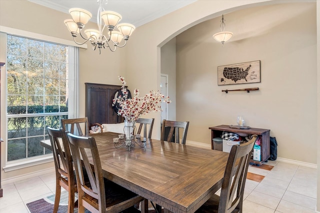 tiled dining space with crown molding and an inviting chandelier