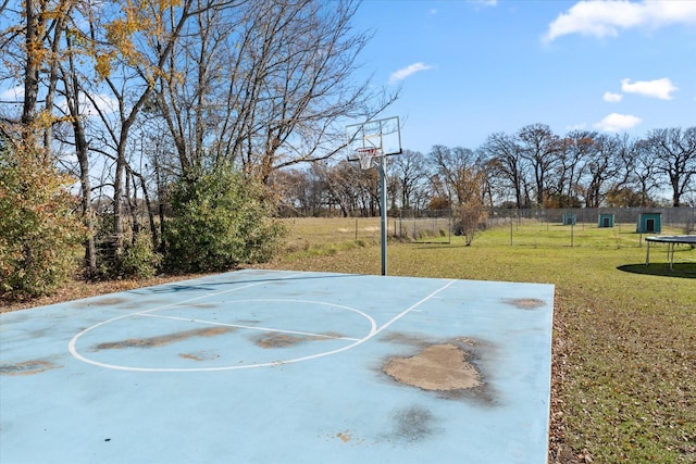 view of basketball court featuring a yard and a trampoline