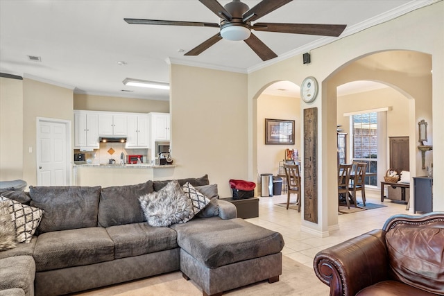 living room featuring light tile patterned floors, ceiling fan, and crown molding