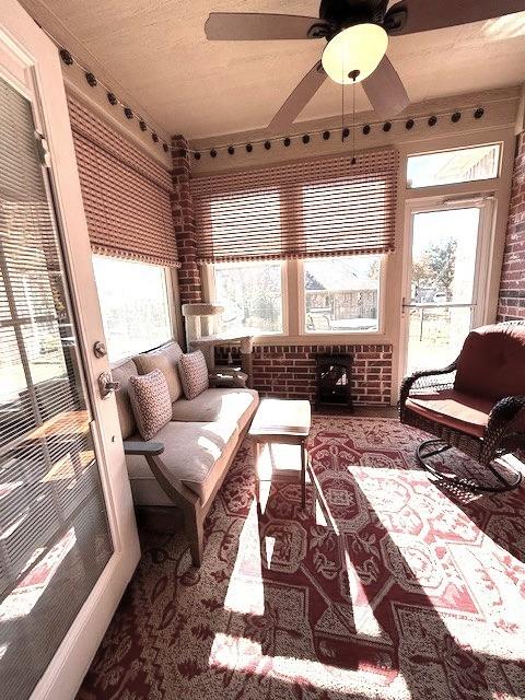 sunroom / solarium with plenty of natural light and ceiling fan