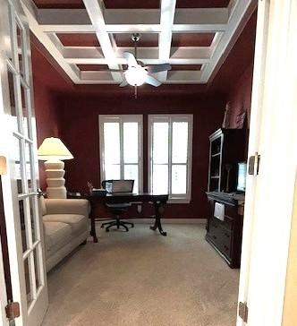 carpeted office space with coffered ceiling, plenty of natural light, beam ceiling, and french doors