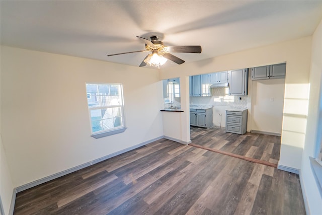 kitchen featuring ceiling fan, gray cabinetry, dark hardwood / wood-style flooring, and decorative backsplash