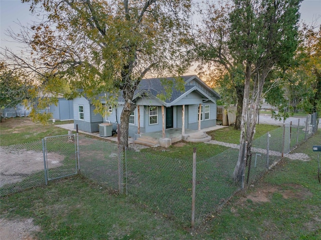 view of front of house with cooling unit and a yard