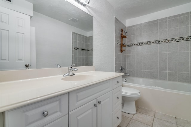 full bathroom featuring tiled shower / bath combo, vanity, tile patterned floors, and toilet