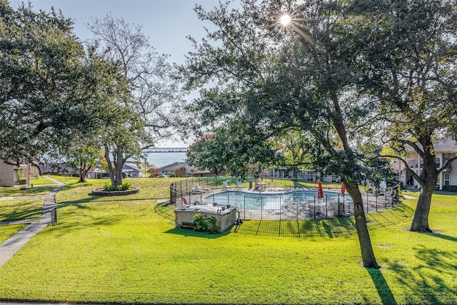 view of property's community with a swimming pool and a yard